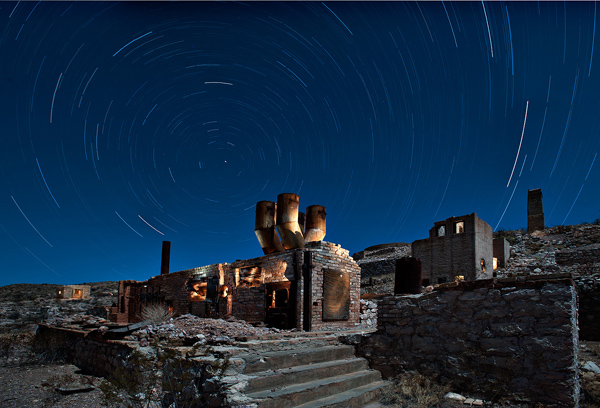 Star trails and illuminated desert landscape