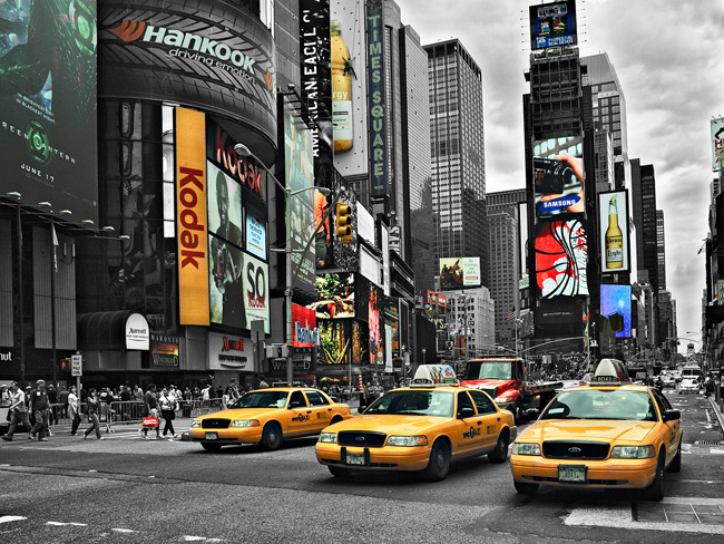Yellow taxis against a monochromatic cityscape