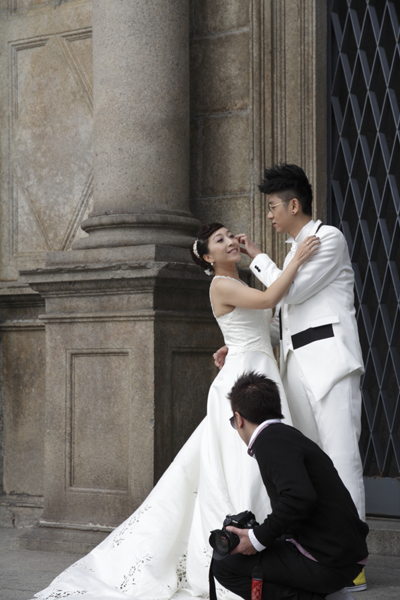 A Photographer Readies a Couple for a Wedding Photo