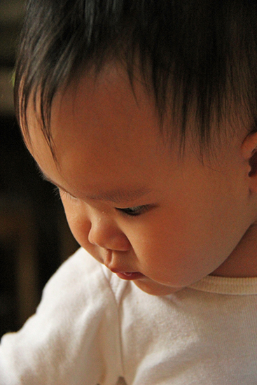 Face of Young Chinese Child Looking Down with Serious Expression
