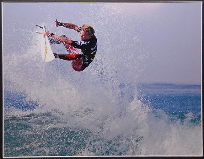 Surfer suspended in air above a large wave