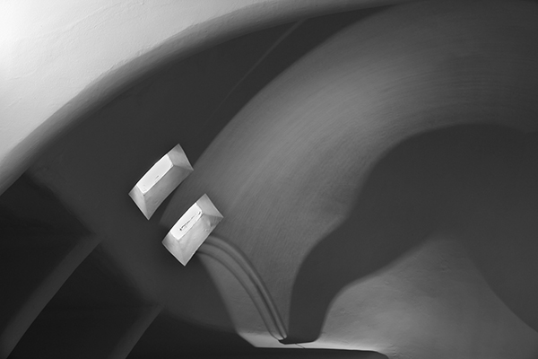 Curved attic ceiling with light coming through two windows