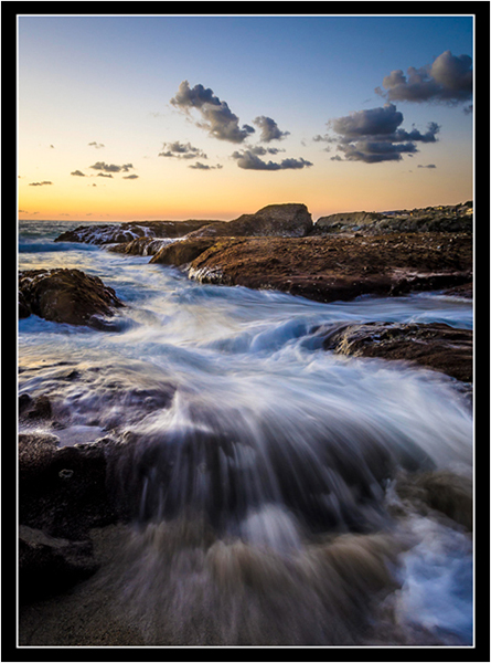 Waves Crashing on Rocks at Sunset