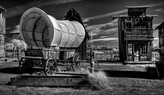 Covered Wagon inside Old Fort with Pump and Sagegrush in Foreground